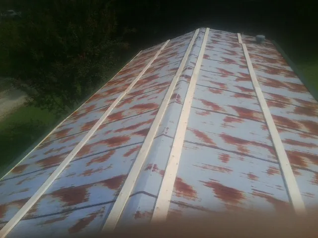 Rusted metal roof panels with new wood purlins before replacement — Storm Damage Roof Repair in Drifton by Roofing Brothers