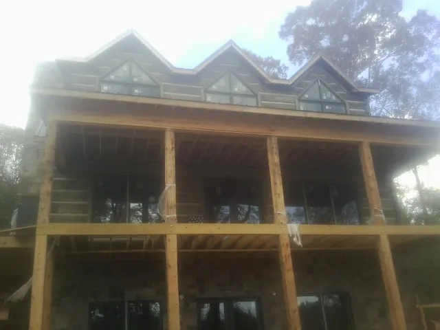 Dormers and porch framing on a large log home under construction — Roof Coating work by our crew in Drifton