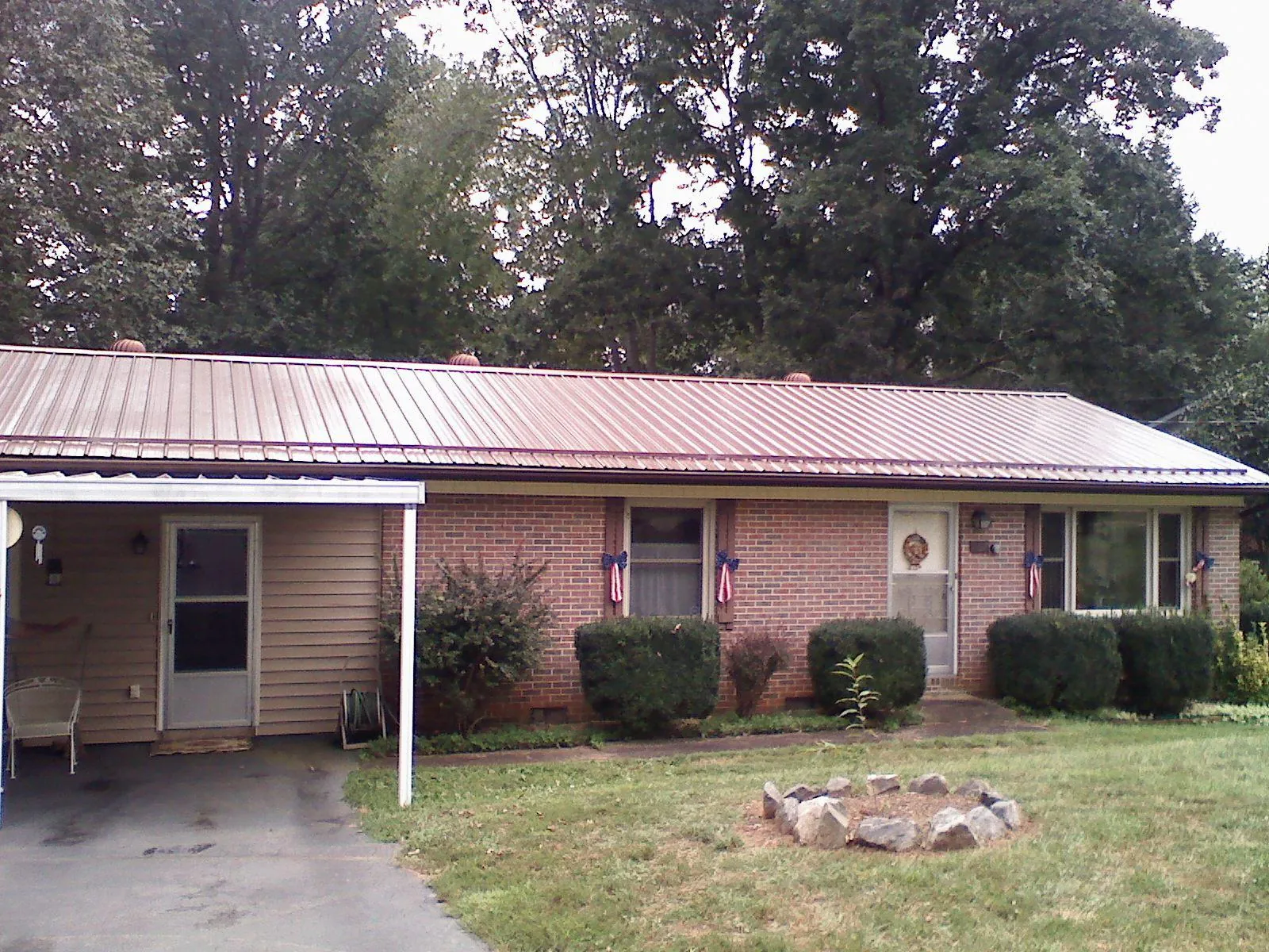 Bronze metal roof and carport on a brick ranch home — Roof Repair work by our crew in Drifton